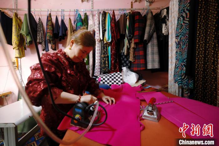 和田地区皮山农场的一间裁缝店内，店主布阿米乃·赛迪艾合买提正在忙碌。中新社记者 韩海丹 摄