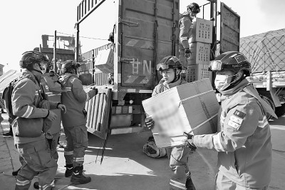 12月19日，在甘肃临夏州积石山县大河家镇大河村安置点，消防人员在搬运救援物资。新华社记者 方欣摄