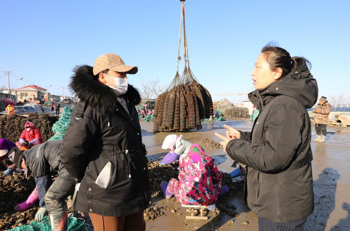 建设银行大连长海县支行信贷负责人（右）向牡蛎养殖户了解信贷需求情况。李敬伟/摄