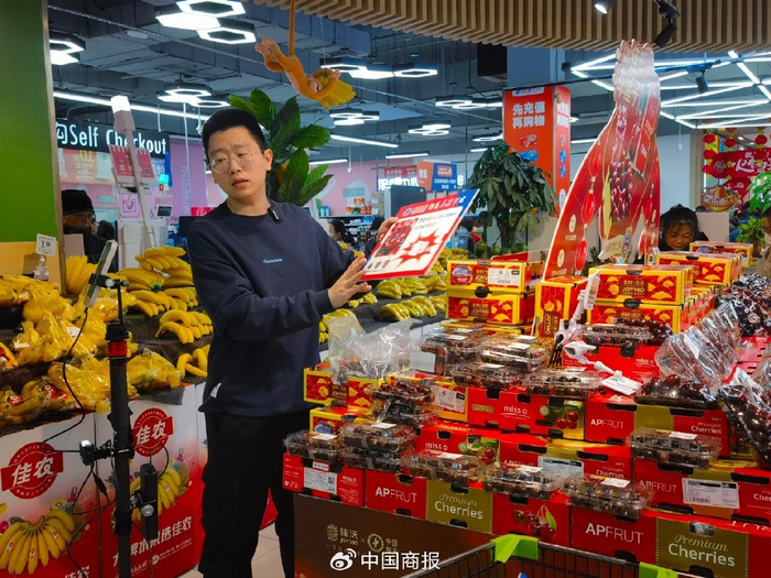 工作人员正在超市直播售卖车厘子。