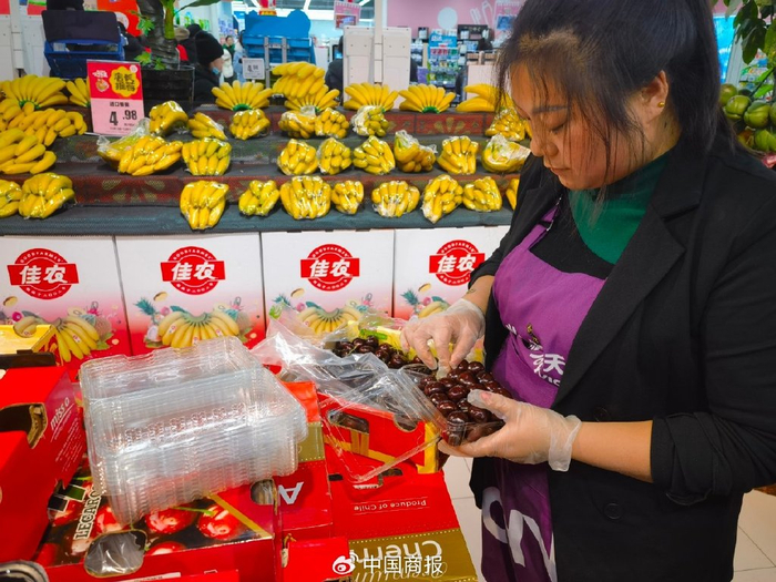 超市工作人员正在对车厘子进行分装。