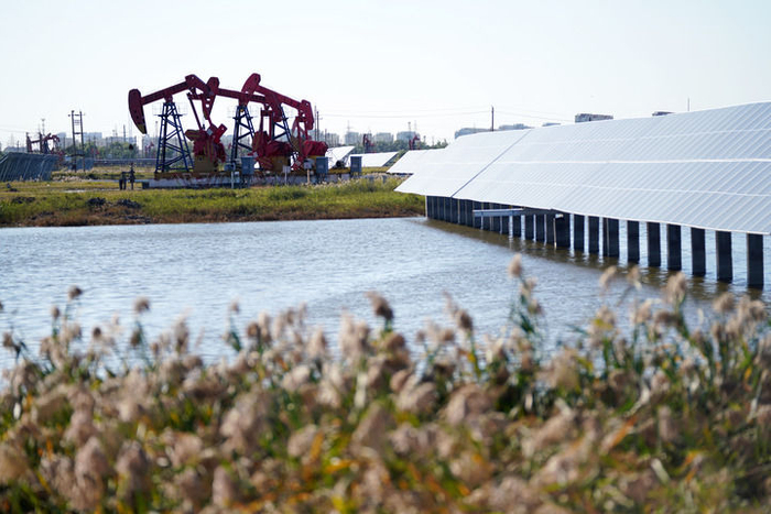 2023年9月19日，在黑龙江大庆油田星火水面光伏电站，电站设施与附近的抽油机相映成趣。新华社记者 王建威 摄