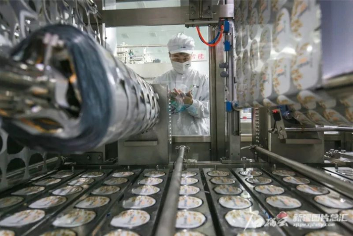 位于呼图壁县的新疆西域春乳业有限责任公司的生产车间里，员工在检查产品质量（资料图片）。马光元摄