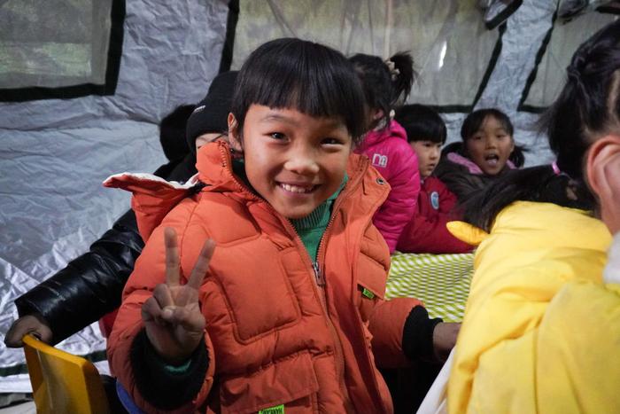 12月22日，甘肃省临夏州积石山县大河家镇康吊村，小朋友在安置点的“帐篷小课堂”参加集体活动。新华社记者 马希平 摄