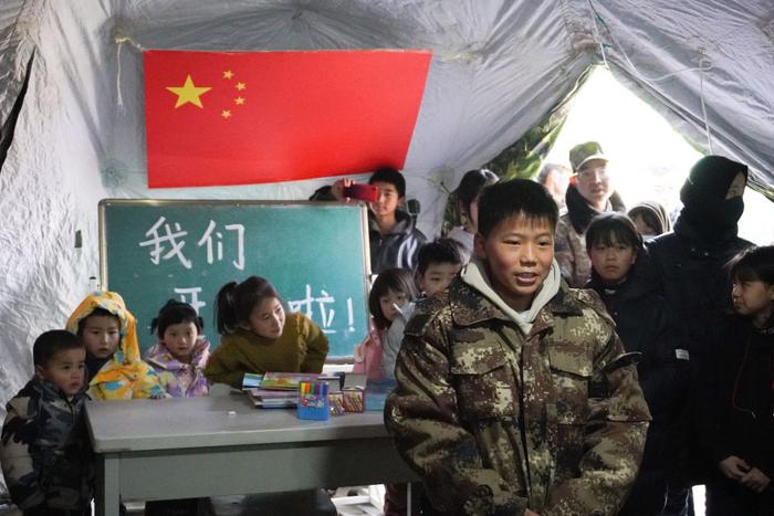12月22日，甘肃省临夏州积石山县大河家镇康吊村，一名小朋友在安置点的“帐篷小课堂”内表演节目。 新华社记者 马希平 摄