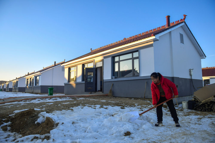 2023年12月7日，吉林省舒兰市开原镇新开村村民徐中仁在新房门前清理积雪。新华社记者 许畅 摄
