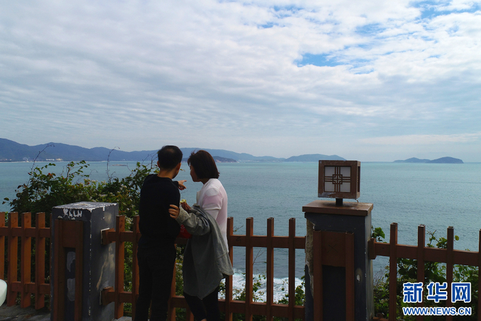 游客在环岛旅游公路三亚太阳湾路段欣赏风光美景。新华网发