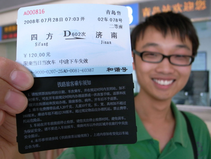 ↑2008年7月25日，乘客在青岛火车站展示磁卡火车票。新华社发