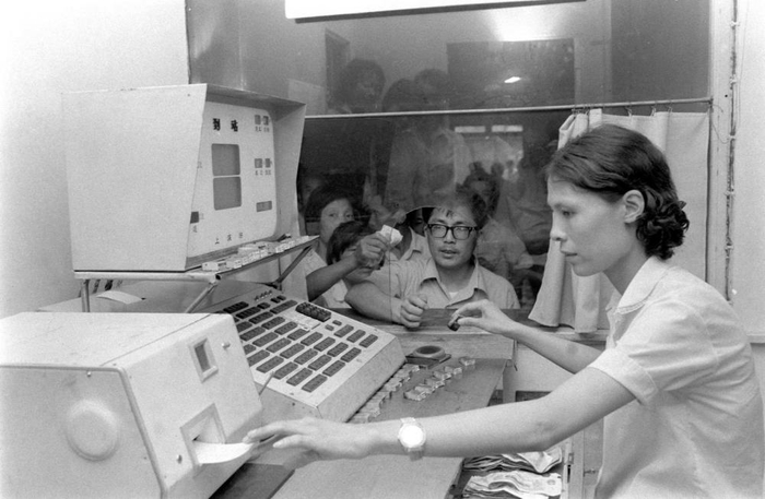 ↑1981年，上海铁路局上海客运站的售票员，正在使用计算机控制的售票机售票。新华社记者张平摄