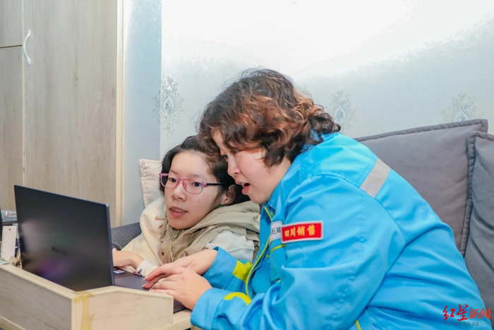 ▲在爱心企业帮助下，唐欣（左一）有了一台电脑