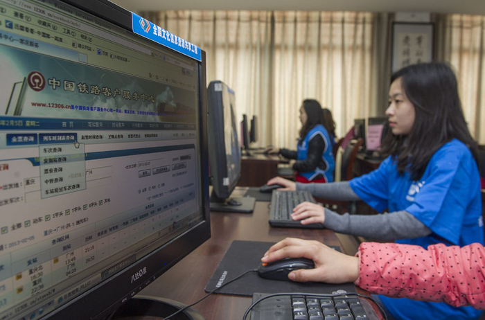 ↑2013年2月6日，重庆市渝北共青团市民学校的志愿者在网上帮助需要订票的农民工朋友购票。新华社记者陈诚摄