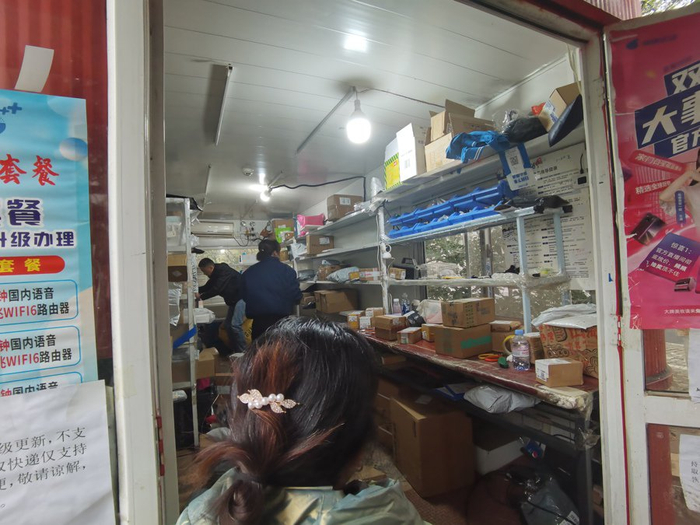 △既要收货理件，又要给居民取件，两名“兔喜”员工忙得不可开交，能承担社区安全志愿者职责吗？