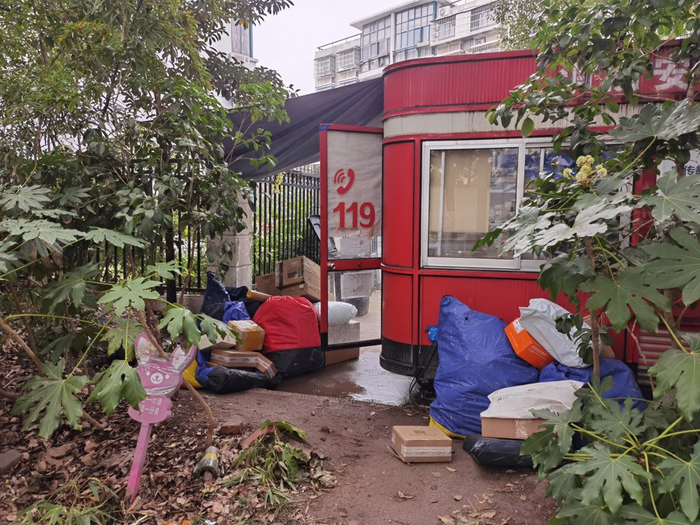 △刚卸车的快递堆在“社区综合服务站”旁，等待两名“兔喜”的工作人员清理上架。