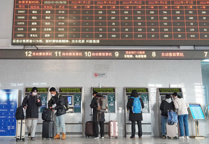 ↑2022年1月3日，旅客在南京火车站售票大厅的自动售票机前排队购买车票。新华社发（方东旭 摄）