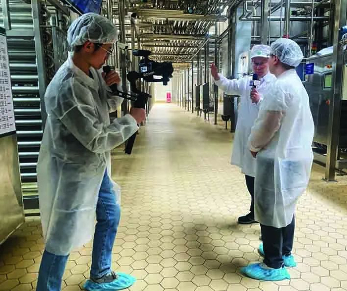 　　图为蒙牛曲靖工厂负责人马福利向记者介绍如何通过优化车间设计，削减生产能耗