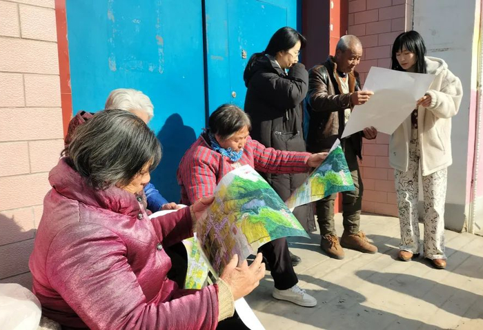 村民正在欣赏手绘旅游导览图年画