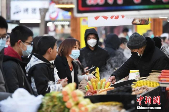 图为游客、市民排队购买崇文街内小吃。白永民 摄