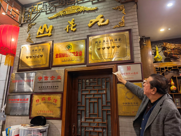 王秋生擦拭店内荣誉奖牌