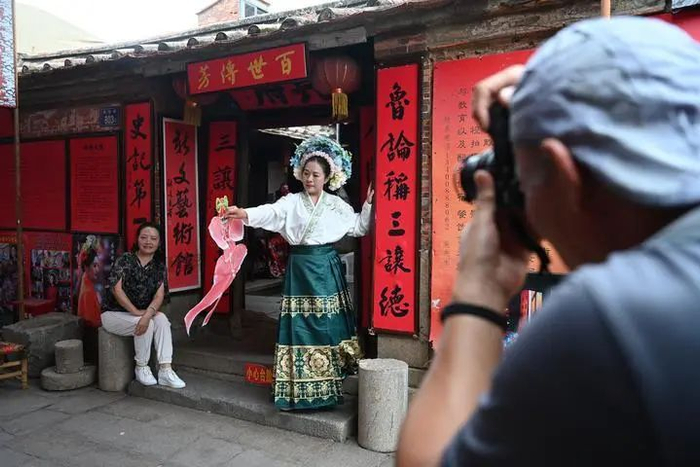 10月27日，体验“簪花围”的游客在泉州市蟳埔村拍照。除署名外组图均由新华每日电讯记者 周义 摄