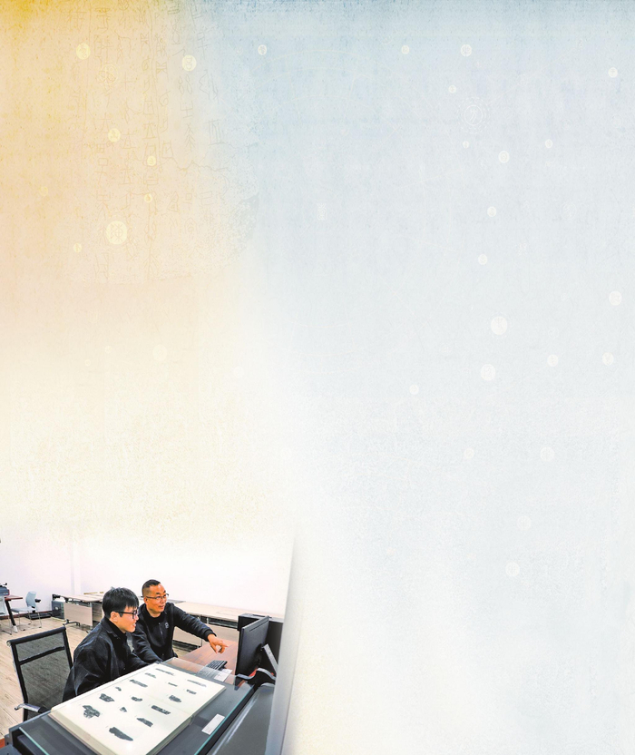 刘永革（右）和研究员在甲骨文信息处理教育部重点实验室工作。 本报记者 杨之甜 摄