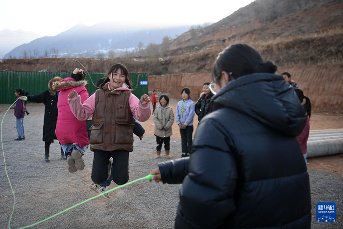 12月27日，在积石山县大河家镇梅坡小学临时教学点，学生在临时操场跳大绳。新华社记者 范培珅 摄