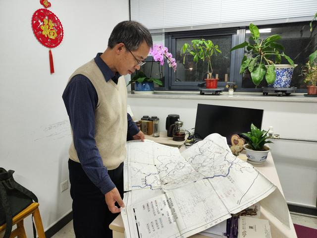 2023年12月，在北京大学城市与环境学院办公室，陈耀华打开景迈山地图介绍。新京报记者 吴采倩 摄
