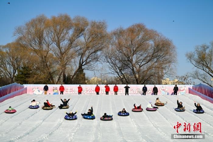12月27日,游客在北京玉渊潭公园体验雪上飞碟项目