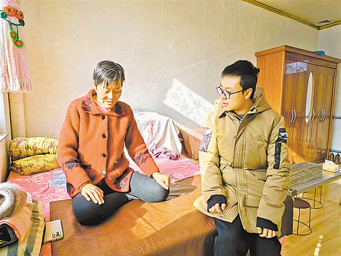 网格员刘团团询问罗润利的妻子病后康复情况。 宁夏日报记者 马越 摄