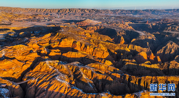 12月24日，霞光映红靖边龙洲波浪谷丹霞景区半边天。