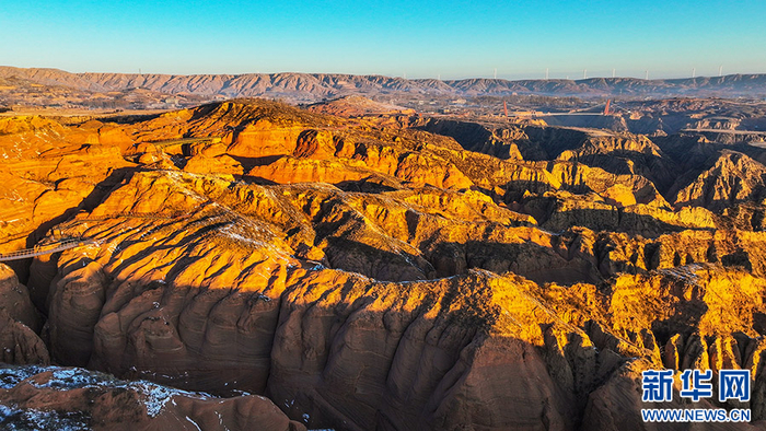 12月24日，靖边县龙洲波浪谷丹霞景区雨雪初霁，红砂岩的色泽会更加鲜艳，同时也会在阳光下形成特殊的光影，景色壮观奇特。