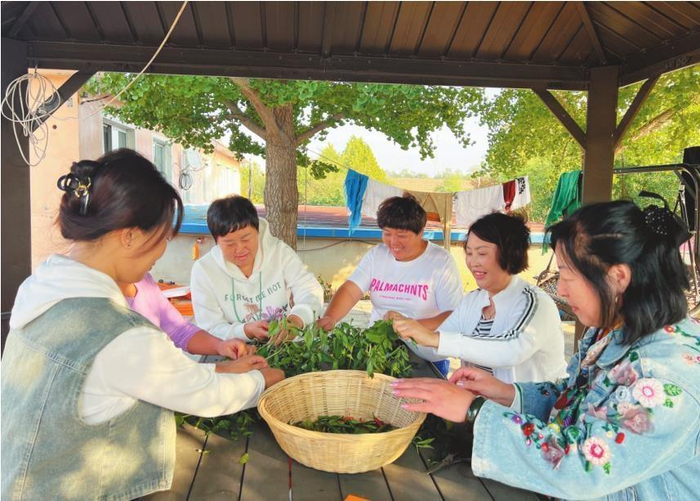         综治中心户赵秀珍（右二）和村民们唠家常，传播和谐友爱的邻里新风尚。    本报记者  王荣琦  摄