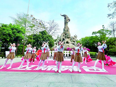 在广州市的五羊雕像前，红领巾起舞飞扬。梁德盈摄/光明图片