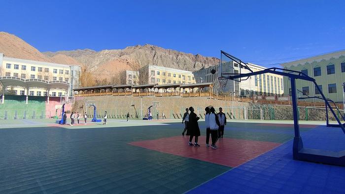 学生在操场上打篮球。本报记者 陈俊 摄