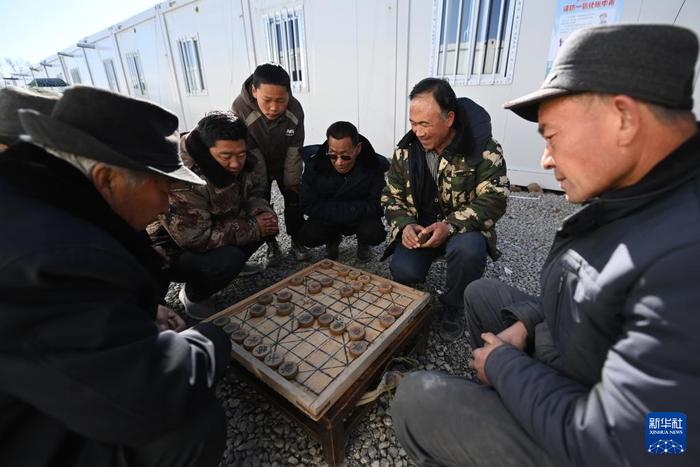 12月29日，在积石山县石塬镇石塬村板房安置点，村民在下象棋。新华社记者 范培珅 摄