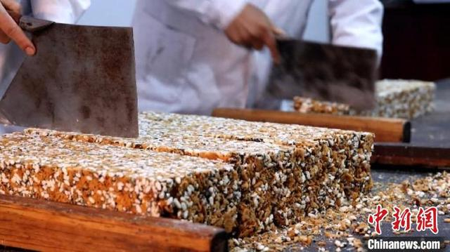 将制作好的红薯冻米糖定型后，用刀切成条状。刘鸿鹤 摄