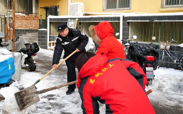 为方便居民出行，李建忠和社工一起铲雪。图源：北京市公安局东城分局