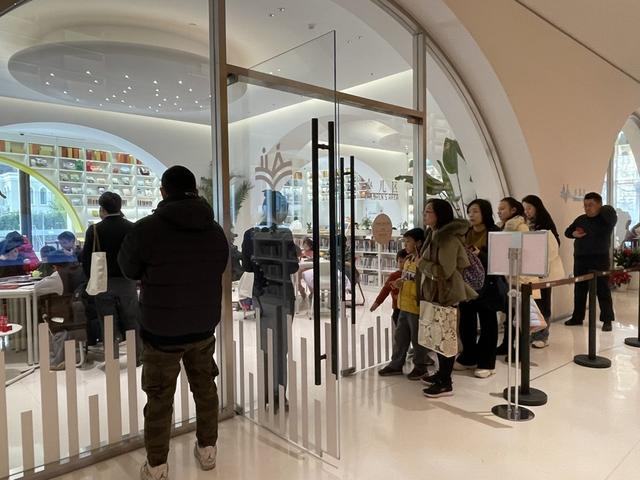 元旦当天，徐家汇书院少儿阅览区外，不少家长带孩子排队进馆。 舒抒 摄