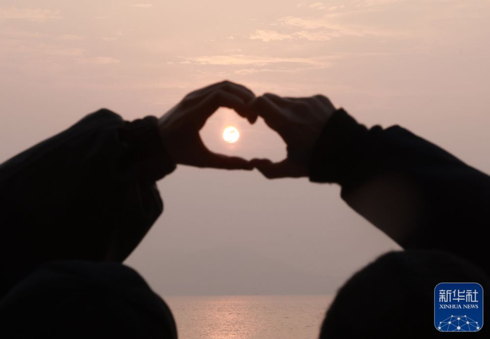 1月1日，游人在武汉东湖风景区迎接新年日出。新华社发（赵军摄）