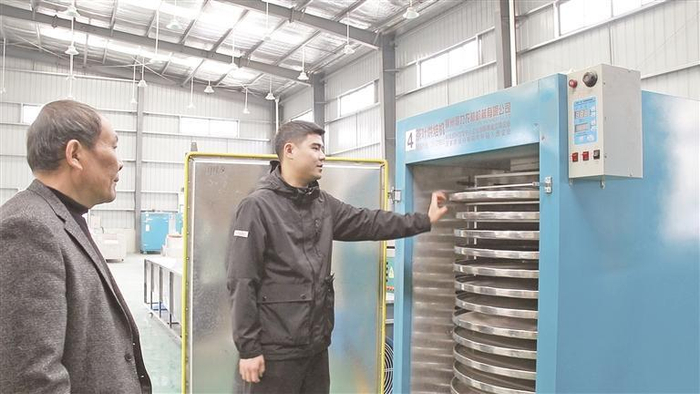     陈伟强（左）在普安红集团制茶车间和黄治龙交流。 （普安县融媒体中心供图）