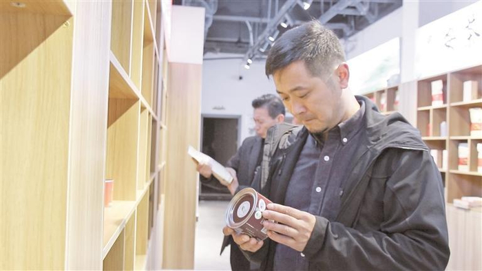     马建波查看普安红集团展厅摆放的成品茶。 （普安县融媒体中心供图）