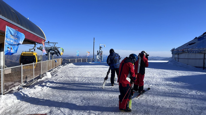 雪友乘坐缆车到达顶峰，准备畅享滑雪的速度与激情。