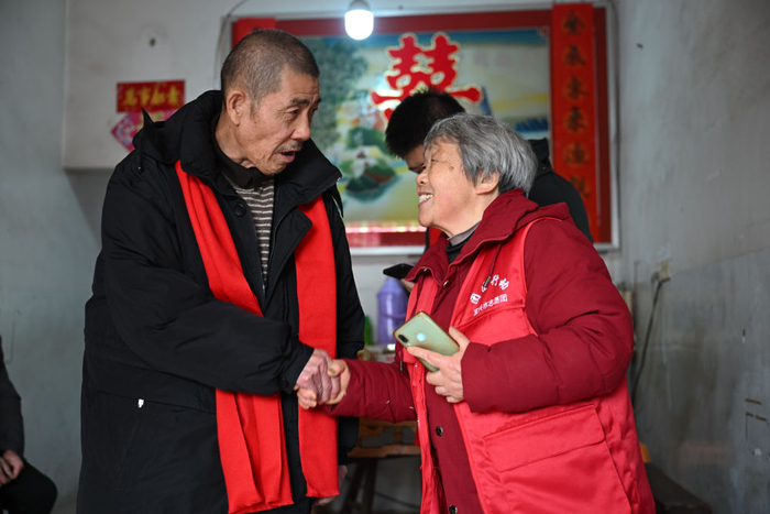 2023年12月31日,在江苏省常州市溧阳市埭头镇田螺圩村,李永(左)向寻亲