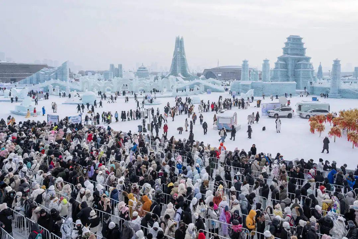 ↑1月1日，游客在哈尔滨冰雪大世界排队等待体验超级冰滑梯。图据新华社