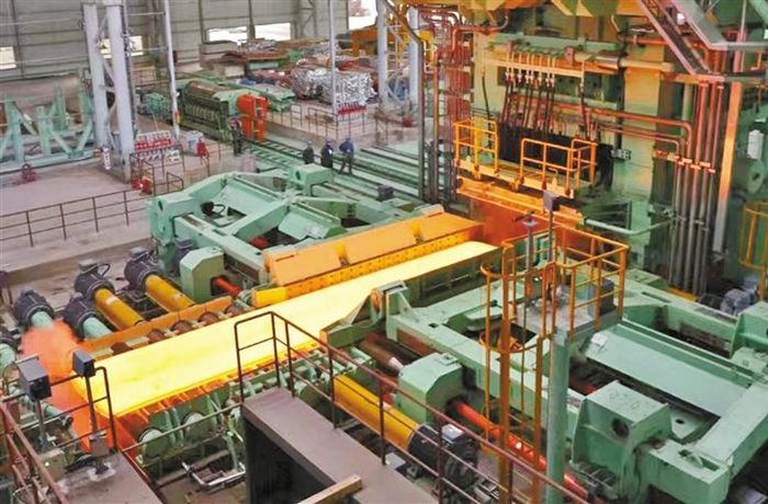 2023年12月19日，汉钢公司生产线上，中厚板坯正经过可逆式轧机进行轧制。