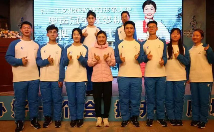 徐梦桃受聘成为扎兰屯文旅体形象大使，聘任仪式后，与“十四冬”志愿者“小雪团”合影。记者 李新军 摄