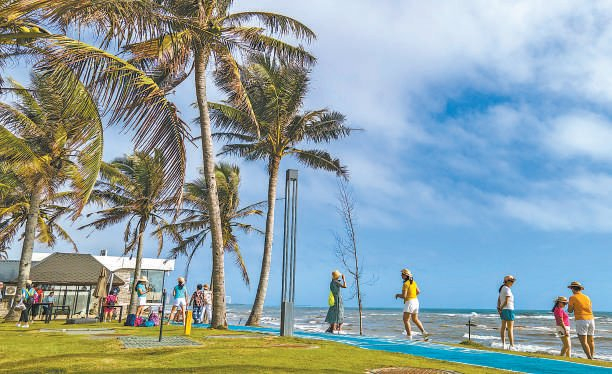 　2023年12月，游客在海南环岛旅游公路琼海博鳌段的海边。蒙钟德 摄