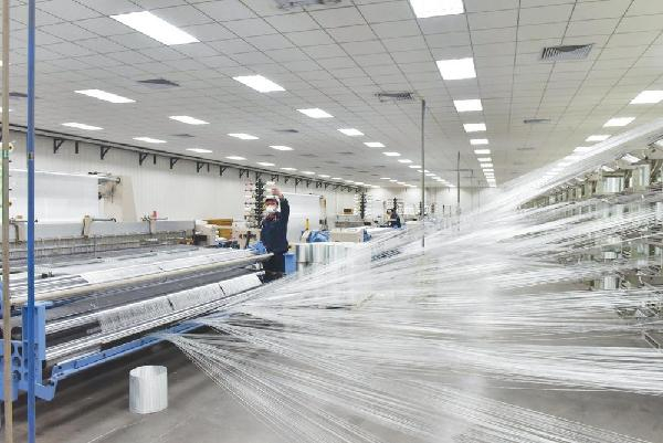沙河市河北冀中新材料有限公司员工正在检查织布机上的纱线张力。 本报记者　叶晓强摄
