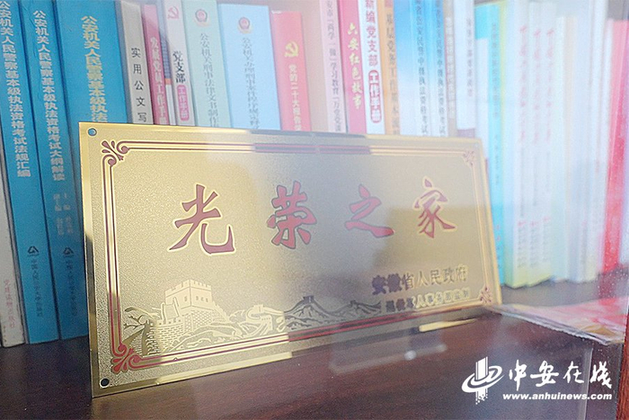 张中建的办公室书柜中"光荣之家"牌匾