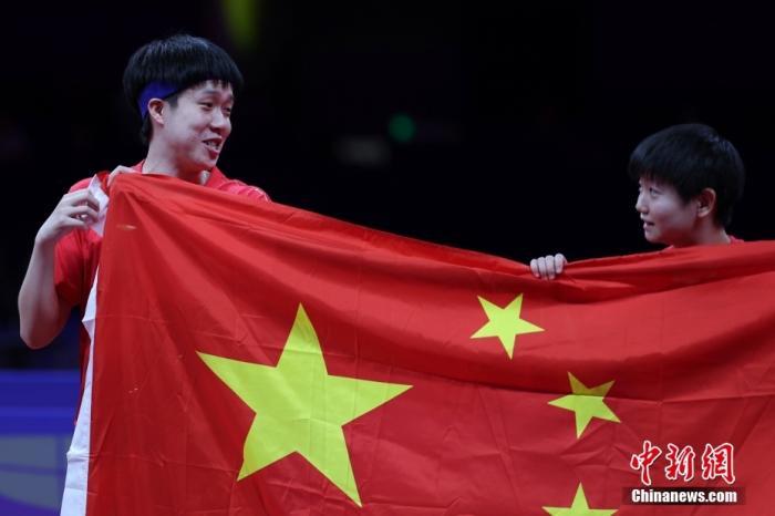   王楚钦,孙颖莎(右)在比赛后展示五星红旗