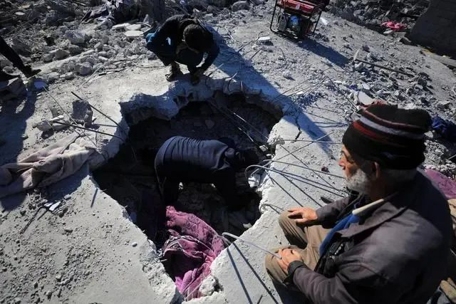 当地时间1月7日，加沙地带南部城市拉法，人们清理以军空袭后的废墟（来源：央视今日关注）